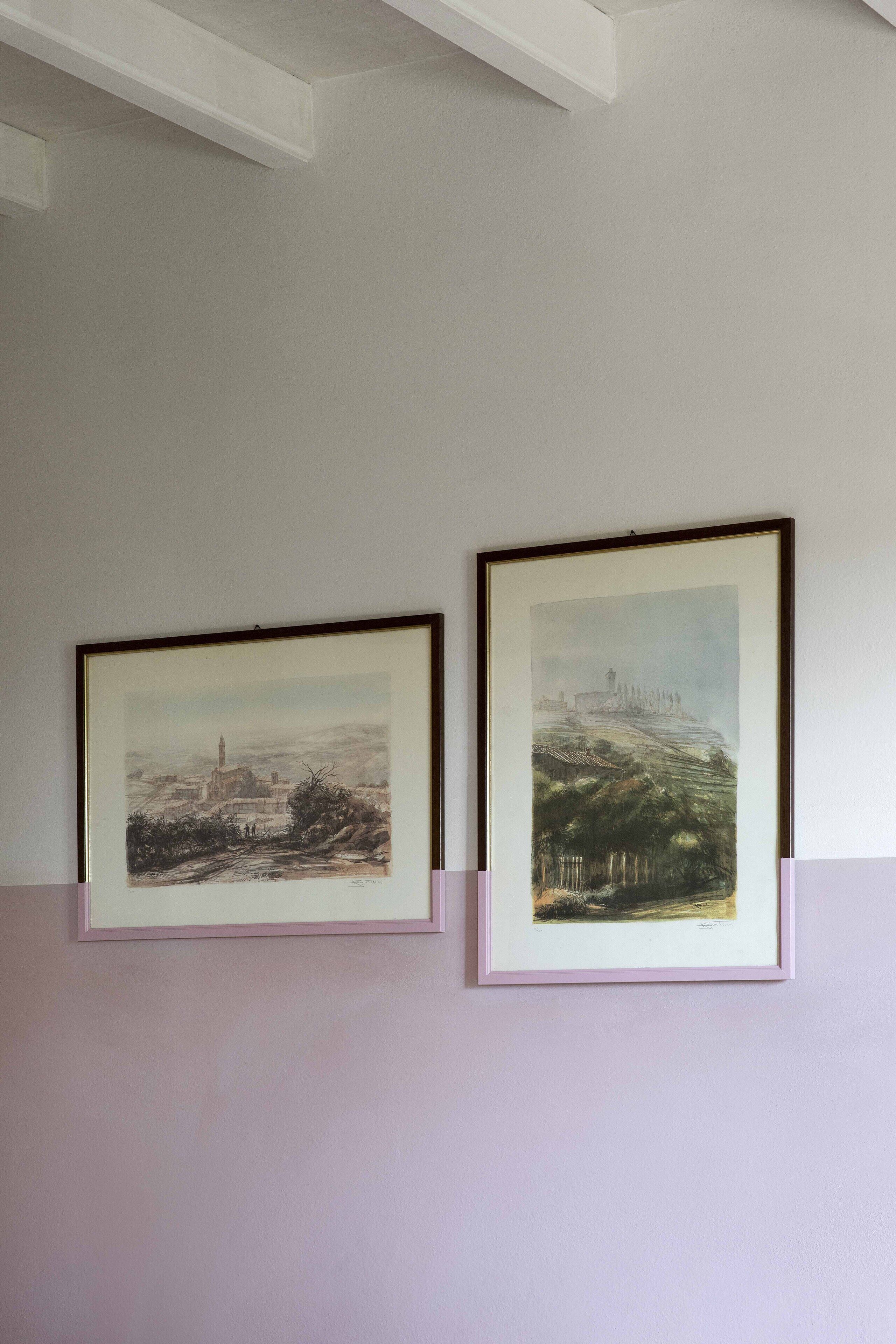 Two framed artworks on a wall.