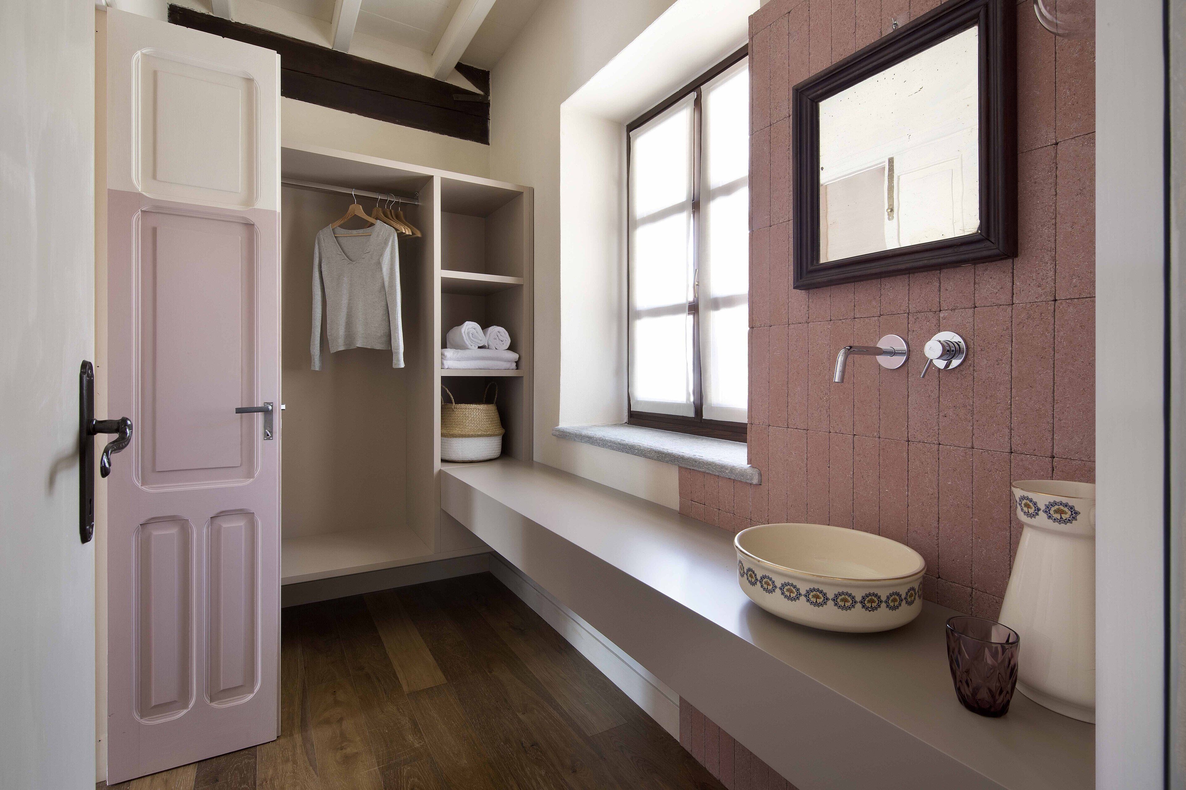 Un baño con un espejo grande, un lavabo con un recipiente decorativo y una ventana con vistas al exterior.