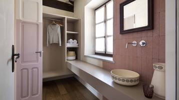 Un baño con un espejo grande, un lavabo con un recipiente decorativo y una ventana con vistas al exterior.