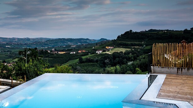 An infinity pool with a view of rolling hills and distant houses. - Agriturismo Ca' del Re (Verduno)