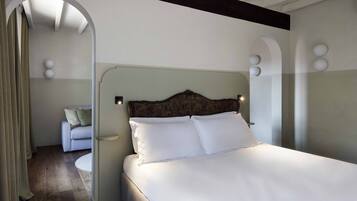 A bedroom with a large bed, a wooden headboard, and a round bedside table.