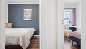 Una camera da letto con un letto, una finestra con tende e un quadro appeso al muro.