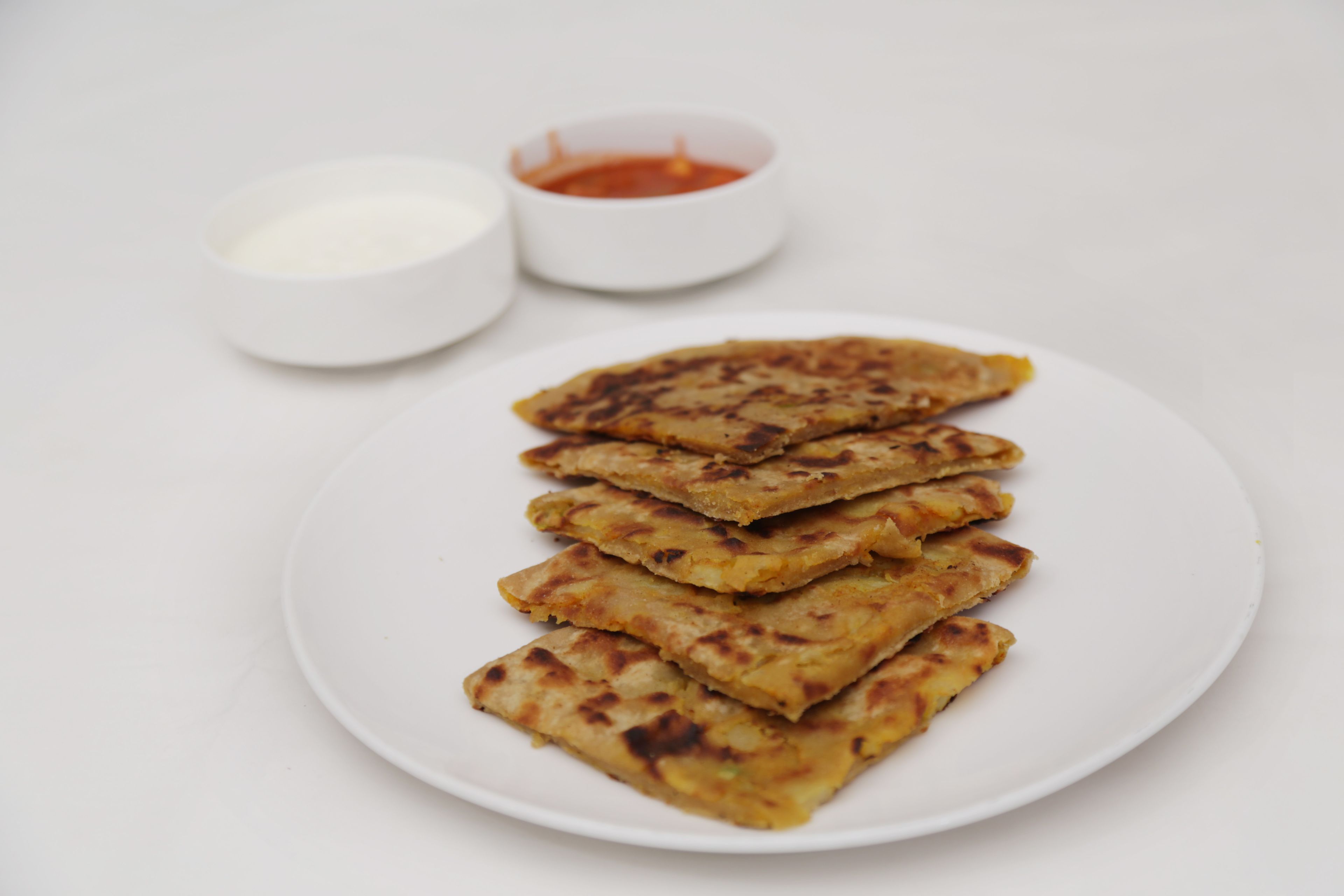 Un plato de comida con dos recipientes pequeños para salsas.
