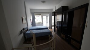 Une chambre à coucher avec un lit, une armoire et un bureau.