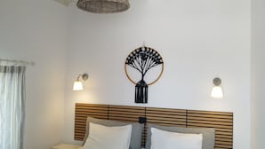 A hotel room with two beds, a woven ceiling light, wall sconces, and a decorative wall piece. - Nikos rooms (Mykonos)