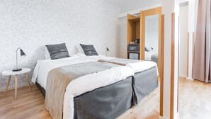 Un dormitorio moderno con una cama grande, una mesita de noche y un espejo.