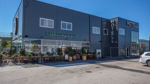 Un edificio moderno con un letrero que dice 'ESPRESSO HOUSE' y 'HOTEL'.