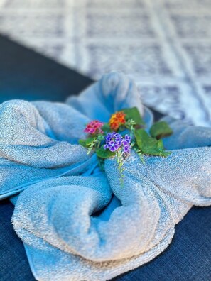 A folded towel with a small flower arrangement. - Hotel Maritza (Cahuita)