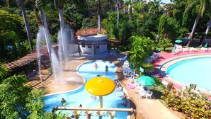 A water park with multiple pools, a water slide, and a pavilion. - Agape - Hot Springs Apart Hotel (Caldas Novas)