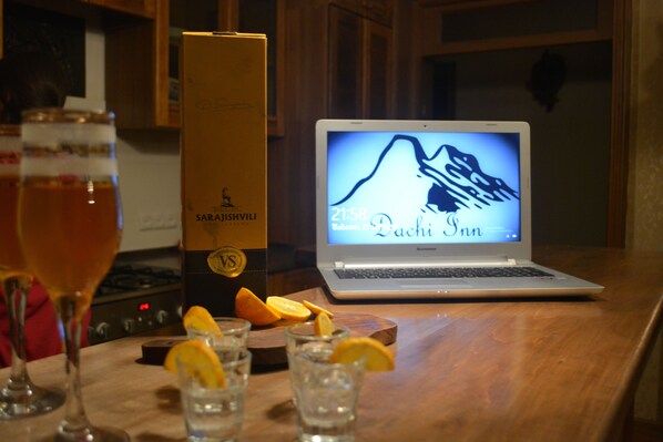 Una laptop sobre una mesa de madera mostrando el nombre de un hotel y la hora.
