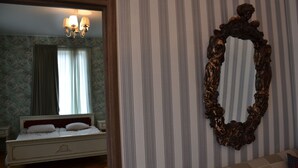 Une chambre à coucher avec un lit, un miroir et un lustre.