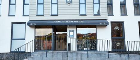 A hotel entrance with a sign reading "The Garrison" and a "Bistro" sign.