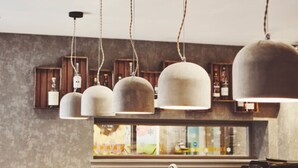 Un interior moderno con iluminación colgante y estantes de madera que exhiben botellas.