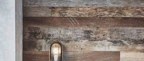 A rustic wooden wall with a single lantern.
