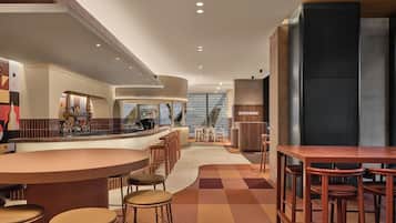 Una cocina moderna con una isla curva, taburetes de bar y vistas a la ciudad.