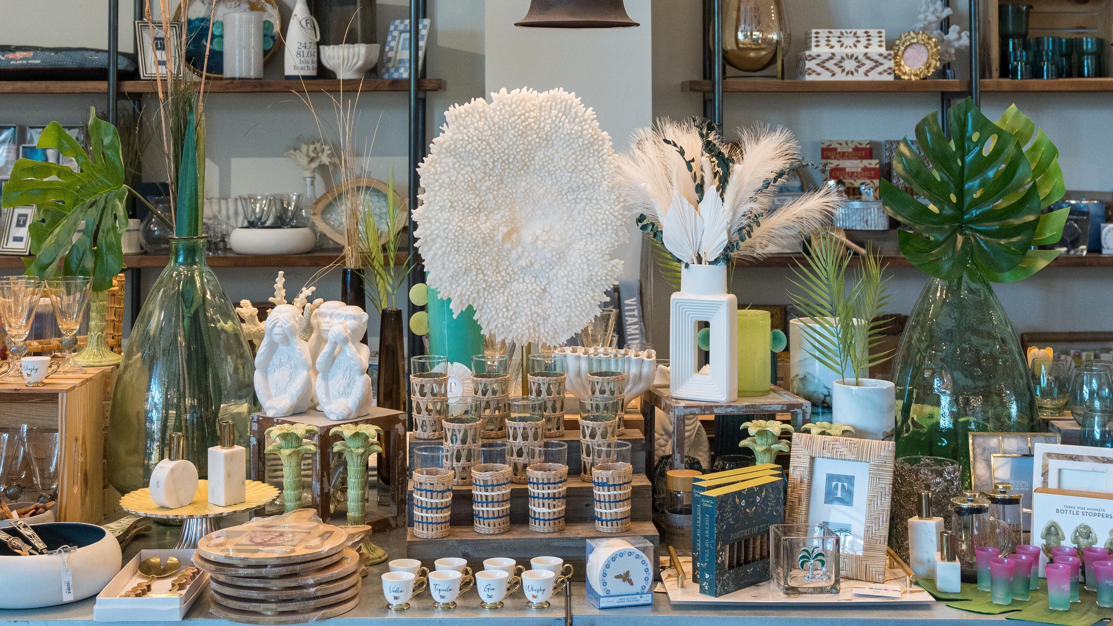 Une variété d’objets en verre et d’articles décoratifs sont exposés, notamment des vases, des assiettes et des porte-bougies.