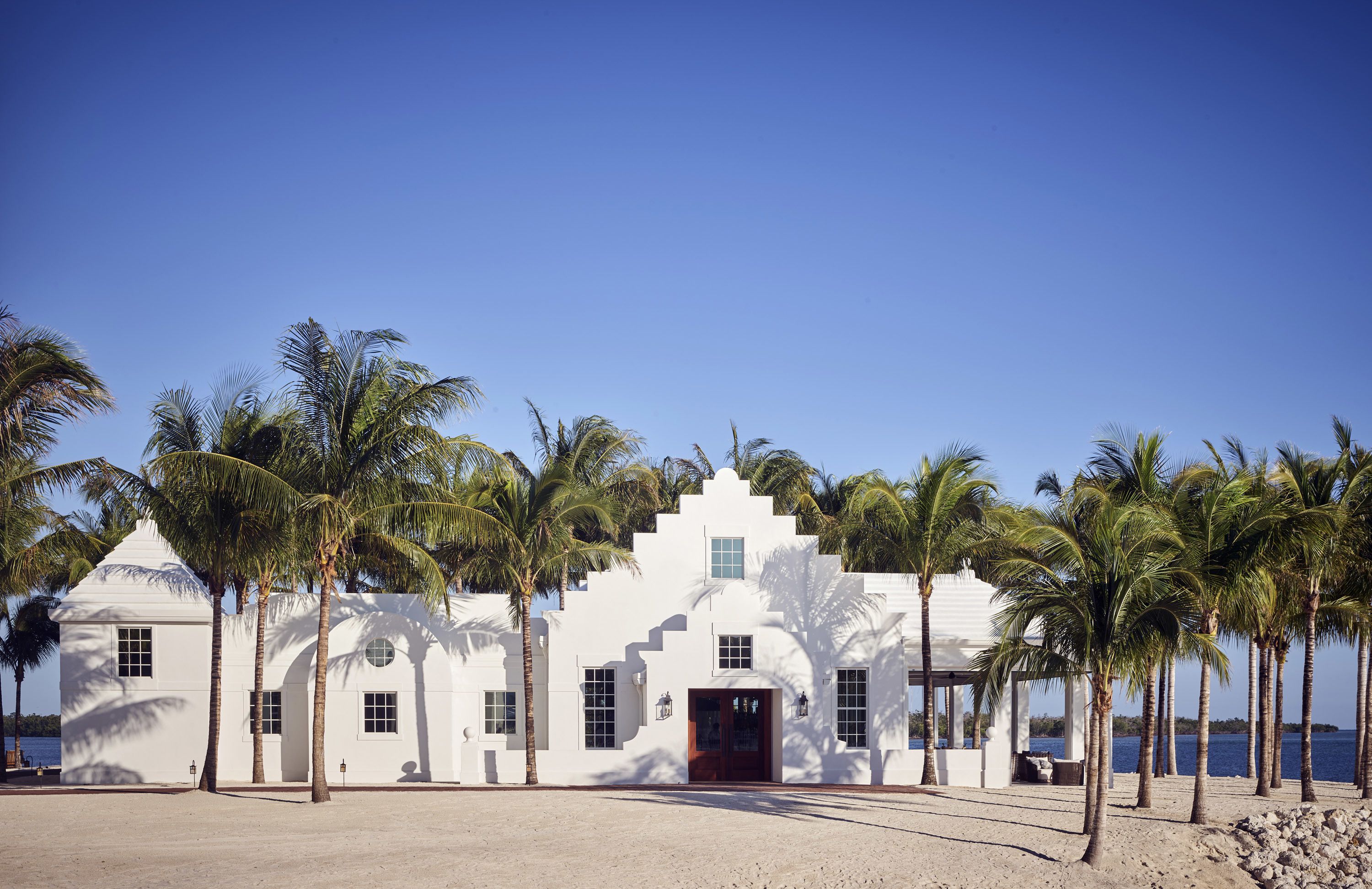 A white building with a symmetrical facade, multiple windows, and a central entrance.