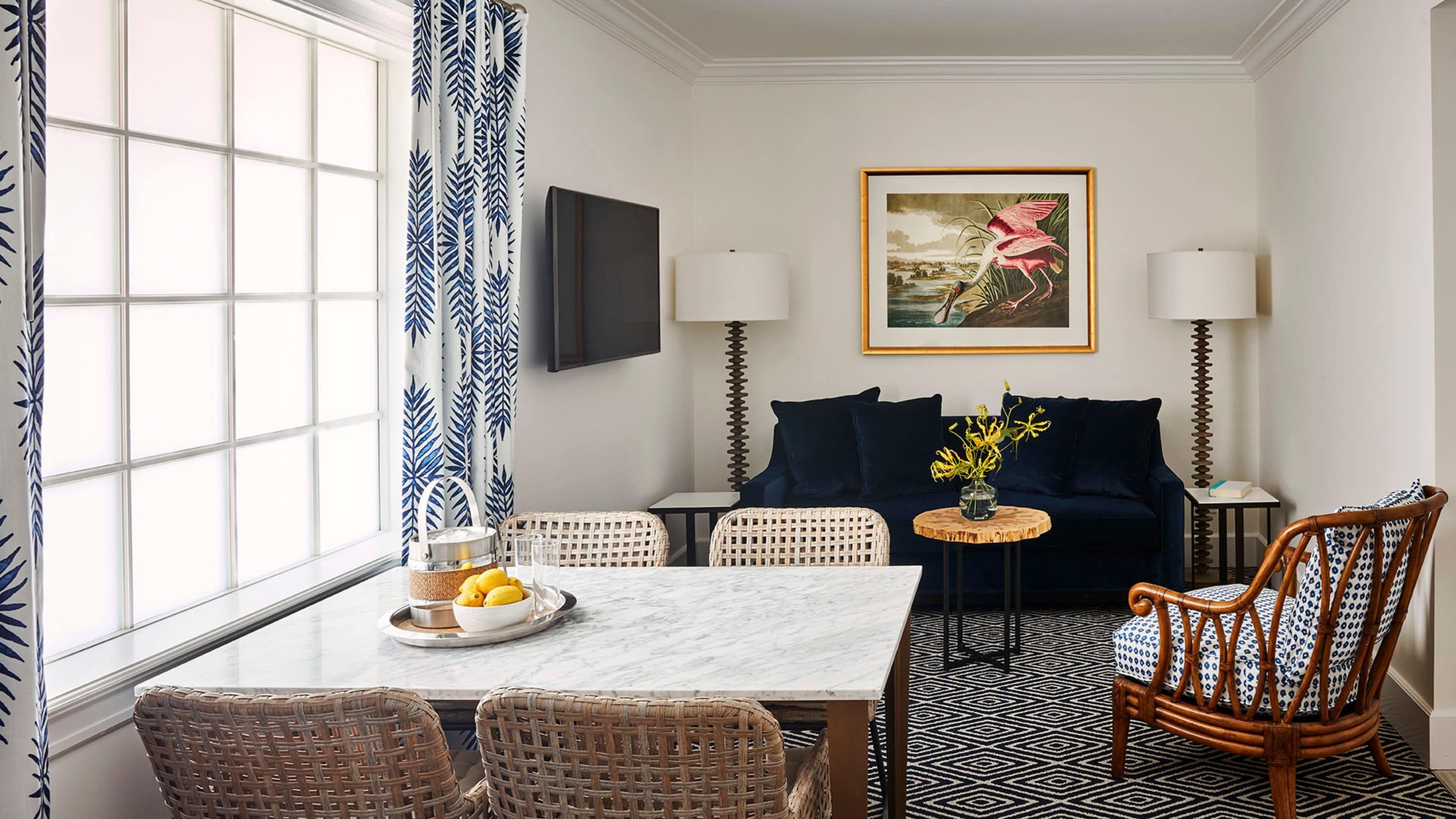Un espace repas comprenant une table, des chaises, un canapé et un tableau accroché au mur.