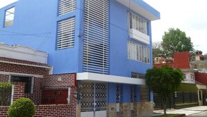 A two-story building with a blue facade, white shutters, and a gated entrance. - La Pension Casa Azul - Hostel (Xalapa)