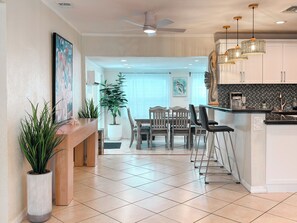 A modern kitchen with a dining area, featuring a central island, pendant lighting, and a view into the dining room. - VILLA TROPICANA | FREE HEATED POOL | BEACHES | PGA | WATERPARK | ROGER DEAN (Palm Beach Gardens)