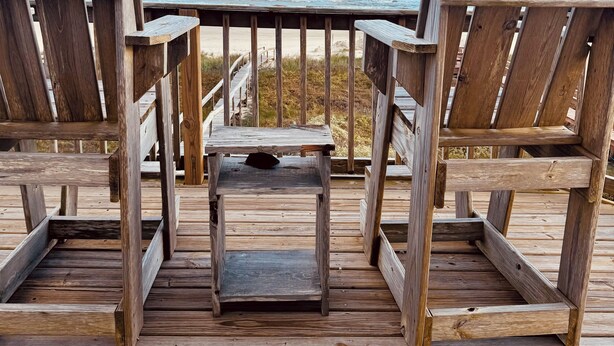 A wooden deck with two Adirondack chairs and a small table, overlooking a beach and ocean. - FRONT ROW SEATS TO THE GULF OF Mexico! There's No Better View  TOTAL RENOVATION (Freeport)