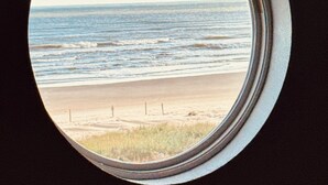 A round window with a view of a beach and ocean. - FRONT ROW SEATS TO THE GULF OF Mexico! There's No Better View  TOTAL RENOVATION (Freeport)