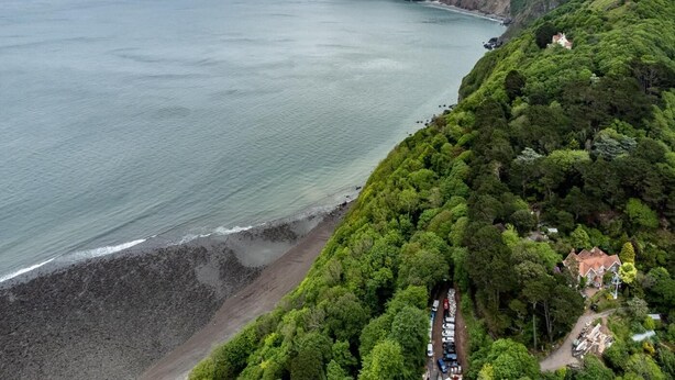A coastal property with a beach, dense greenery, and a house with a red roof. - 2 Bed in Lynmouth (oc-foxcot) (Lynmouth)