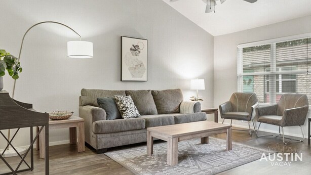 A modern living room with a grey sofa, two armchairs, a coffee table, a floor lamp, and a ceiling fan. - Kinney #4 xxxxxxxxxx (Austin)
