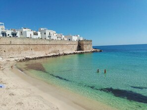 A coastal town with white buildings, clear turquoise water, and a sandy beach. - A step away from the sea - Apartment A / SELENE (Monopoli)