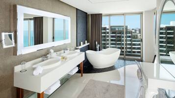 A modern bathroom with a large mirror, two sinks, a bathtub, and a glass shower enclosure.