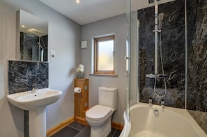 A bathroom with a marble sink, toilet, and bathtub.