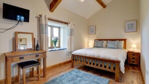 A bedroom with a wooden bed, a desk with a chair, a television mounted on the wall, and a window with curtains. - 2 Bed in Landkey (oc-cartl) (Landkey)