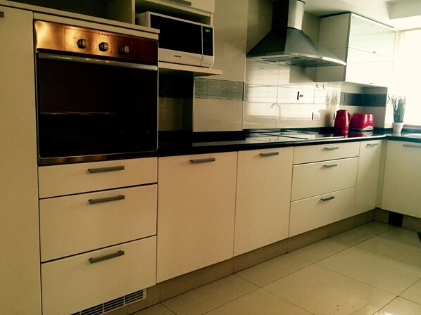 Apartamento luxo, 2 quartos | Cozinha privada | Geladeira grande, micro-ondas, fogão, cooktop