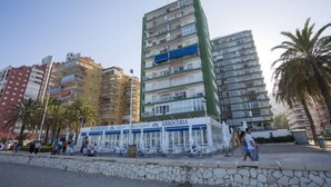 A coastal building with balconies, a restaurant named 'ARROCERIA' on the ground floor, and palm trees in the foreground. - Singular Stays Cullera Beach (Cullera)