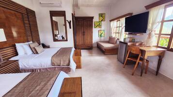 Quarto de hotel com duas camas, uma escrivaninha, televisão e guarda-roupa.