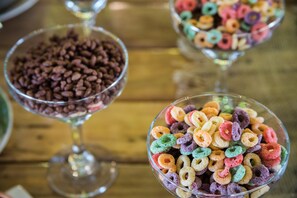 Three bowls of cereal on a wooden table.