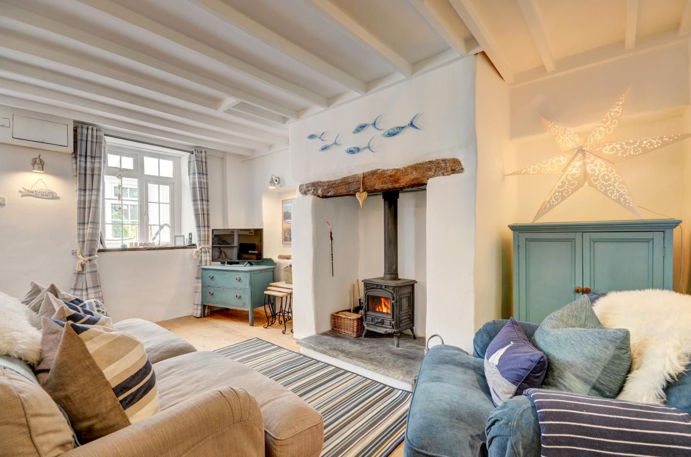 A cozy living room with a fireplace, a television, and a dining area with a table and chairs.