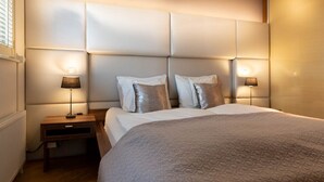A bedroom with a large bed, two bedside lamps, and a headboard with built-in lighting.