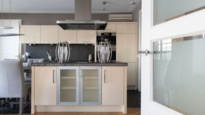 A modern kitchen with a central island, stainless steel appliances, and a minimalist design.