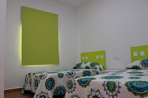 A room with two beds, each with a green headboard, and a large window with a green blind. - Rural house with a private pool (CONIL DE LA FRONTERA)