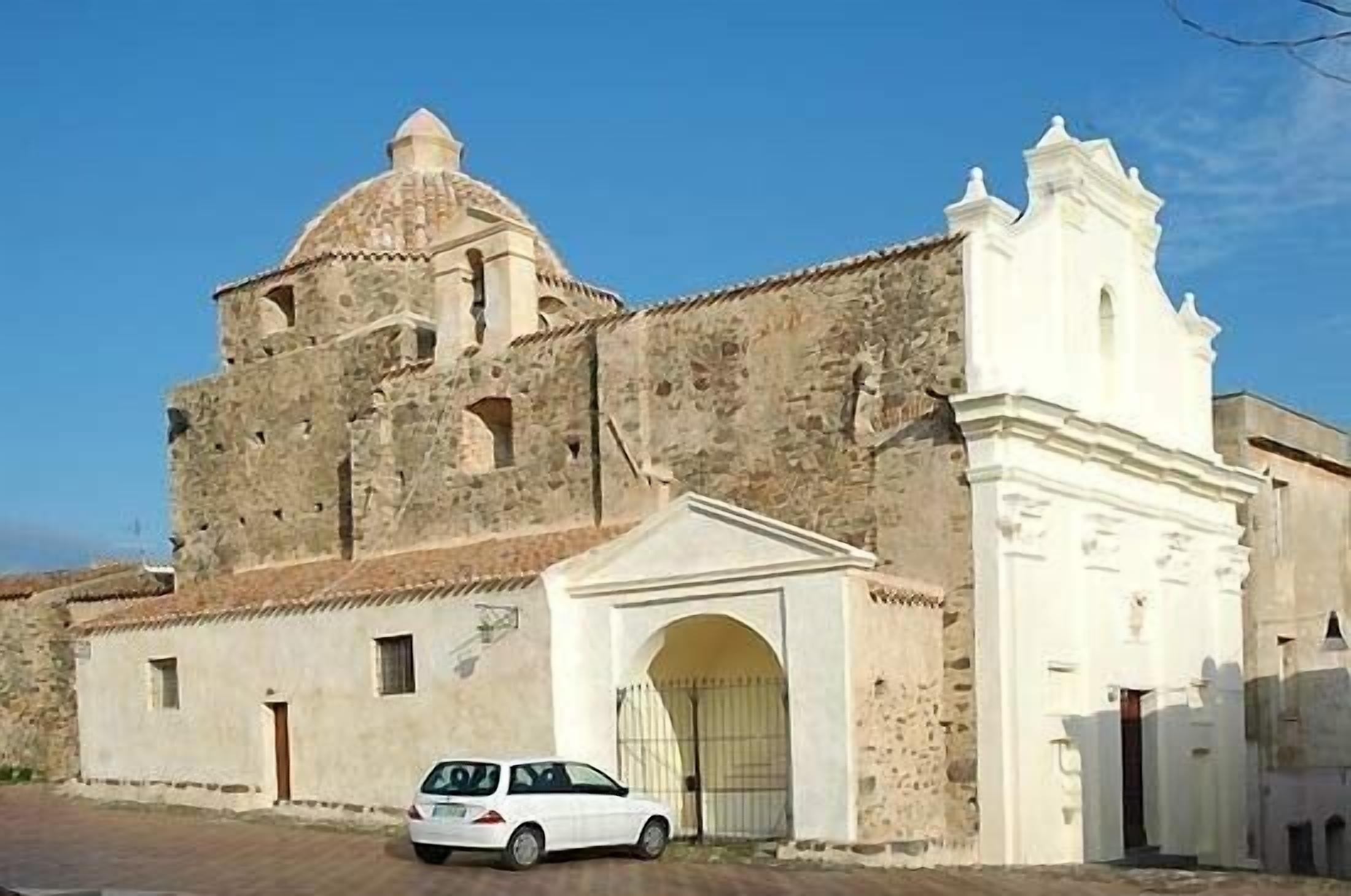 A historic building with a stone facade, a dome, and a white bell tower.