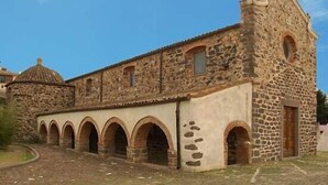 A stone building with a central dome and a series of arches.