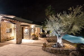 A stone building with a pool, outdoor seating, and a tree. - Provencal villa in unique natural and calm setting with beautiful views (Fayence)