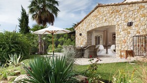 A stone house with a patio, outdoor seating, and a garden. - Provencal villa in unique natural and calm setting with beautiful views (Fayence)