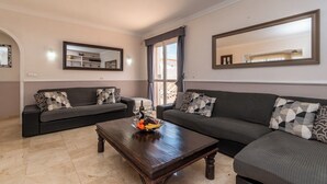 A living room with two sofas, a coffee table with fruit, and a large mirror. - .."Beautiful luxury spacious 4 bed villa Costa Adeje with a heating pool".. (COSTA ADEJE)