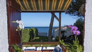 A patio with a wooden bench and cushions, overlooking a garden and a view of the sea. - Seafront house with private access to the sea. Completely renovated in 2016 (Pula)