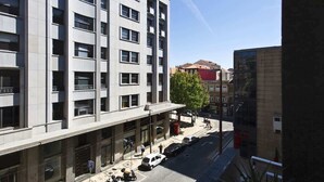 Ein modernes Mehrstöckige Gebäude mit großen Fenstern und einem Eingang im Erdgeschoss.