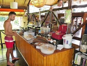 Disposição de buffet com diversos alimentos e uma estação de café.