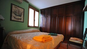A bedroom with a large bed, a chair, and a wardrobe. - B&B Casa Armonia (Pizzo)