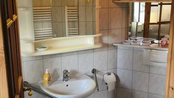 Een haardroger, handdoeken, zeep, toiletpapier